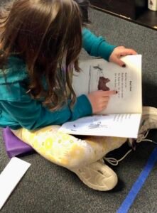 Students reads a book in her lap.